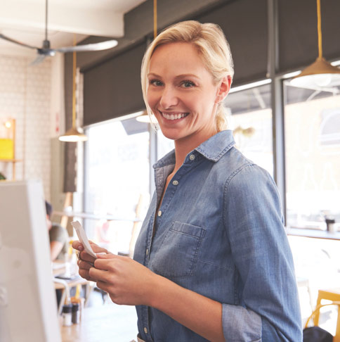Woman smiling at cash register of business